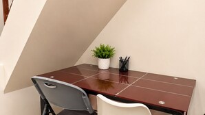 A workspace with a desk, two chairs, a potted plant, and a pen holder. - Tsinoy Villa (Pandi)