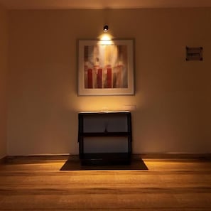 A room with a framed abstract painting, a dark console table, and a wooden floor. - 360 Agonda (Canacona)