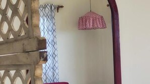 A room with a wooden lattice partition, a red sofa, a round table, and a hanging pendant light. - 360 Agonda (Canacona)