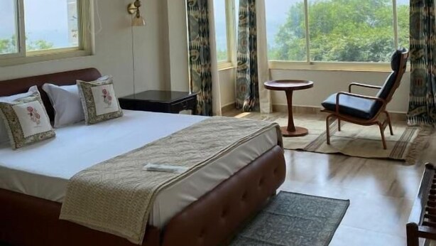 A bedroom with a bed, a ceiling fan, a window, a chair, and a small table. - 360 Agonda (Canacona)