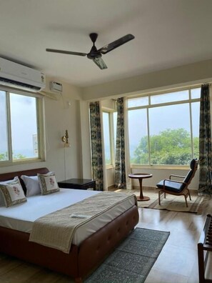 A bedroom with a bed, a ceiling fan, a window, a chair, and a small table. - 360 Agonda (Canacona)