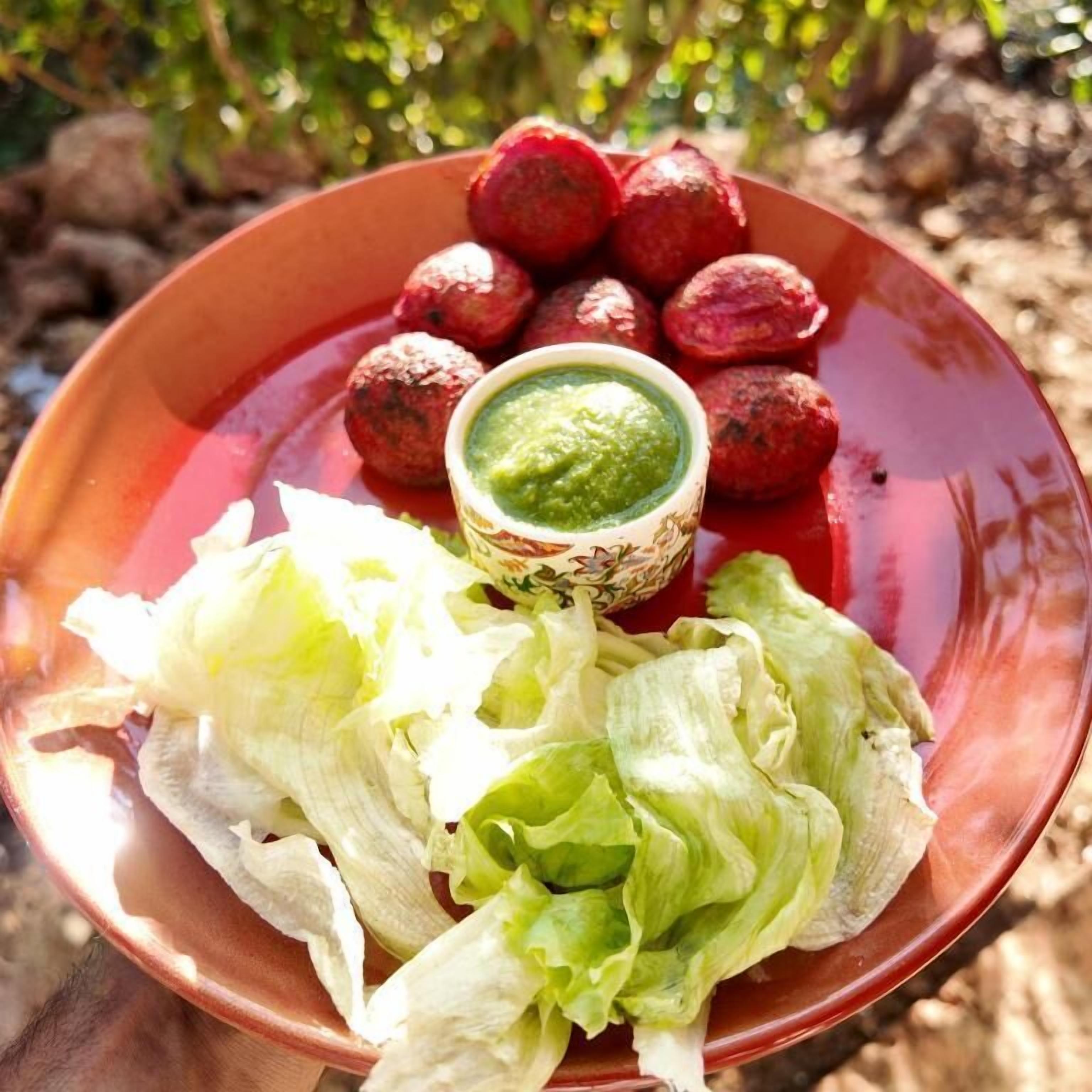 Un plato con alimentos y un bol de salsa verde.