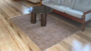 A living room with a sofa, a coffee table, a ceiling fan, and a large window with curtains. - 360 Agonda (Canacona)