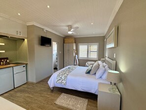 A bedroom with a bed, bedside table, lamp, and a view of the bathroom. - Cozy Studio Retreat in Langebaan, West Coast of South Africa (West Coast District Municipality)