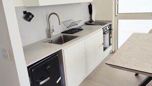 A modern kitchen with a dishwasher, sink, and stove. - Ocean's Edge Suite at 42 Eilat (Eilat)