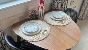 A dining table with two plates, cutlery, and a decorative item. - Luxury King Studio • Heated Floors • Soaking Tub • Seasonal Pool Access (Yreka)