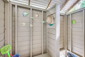 Ein Zimmer mit schräger Decke, Holzwänden, einem Regal mit Flaschen und Fischdekoration.