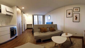 A modern living space with a kitchen, sofa, and dining area. - Modern Studio Apartment (Bogotá)