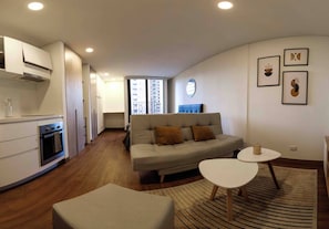 A modern living space with a kitchen, sofa, and dining area. - Modern Studio Apartment (Bogotá)