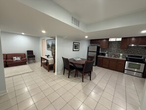 A modern kitchen with a dining area, a living room with a sofa, and a fireplace. - Entire PrivateSuite Separate Entrance Free Parking (Richmond Hill)