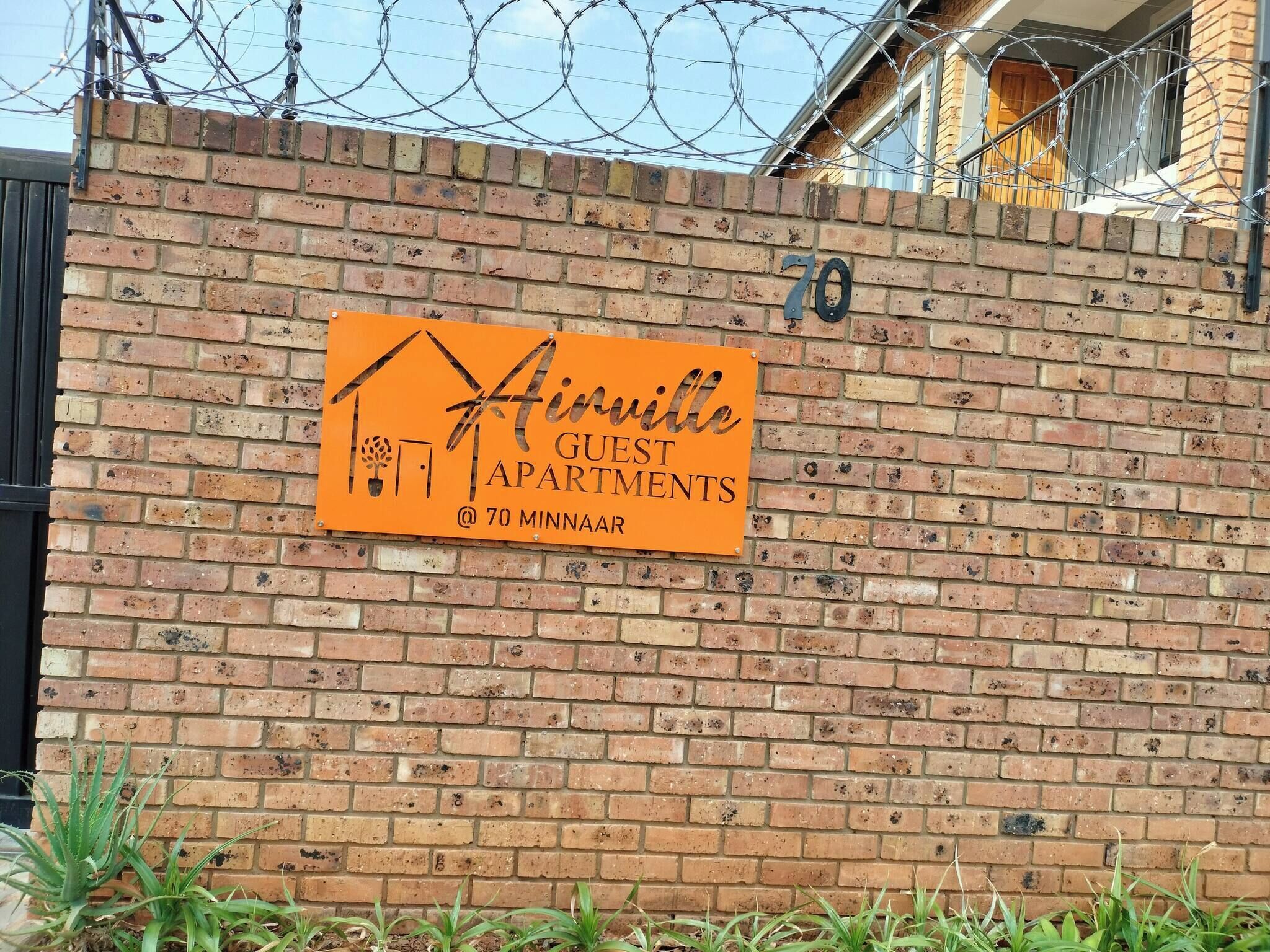 A brick wall with a sign for 'Hiville Guest Apartments' at 70 Minnaar.