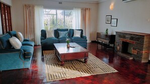 Una sala de estar con un conjunto de sofá, una mesa de centro, una chimenea y vistas al exterior.