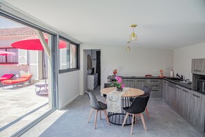 A modern kitchen with a dining area, large windows, and a view of the outside. - A Casa Serena: The soul of Corsica in a picturesque setting... (Santa-Maria-Poggio)