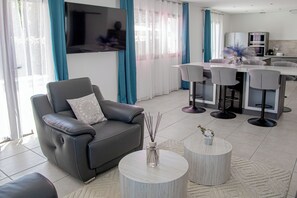 A modern living room with a sofa, a coffee table, and a TV. - A Casa Serena: The soul of Corsica in a picturesque setting... (Santa-Maria-Poggio)