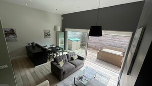 Een moderne woonkamer met een bank, salontafel en een eetgedeelte met stoelen en een tafel.