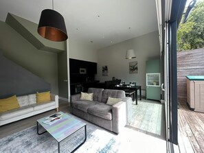 Ein modernes Wohnzimmer mit einer Couch, einem Couchtisch und einem Essbereich mit Stühlen und einem Tisch.