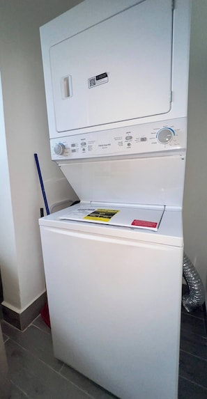 A white washing machine with a control panel, a QR code, and a safety label. - Welcome to Villa Lina (Punta Cana)