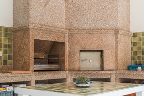 Eine Küche mit Granitarbeitsplatten, einem eingebauten Backofen und einer Edelstahl-Spritzschutzwand.