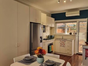A compact kitchen with a refrigerator, stove, and sink. - Cozy home near Swan River-10 mins to Perth City (Applecross)