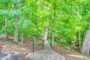 A concrete staircase leading into a forested area with metal railings on the left. - Golf & Lake Gateway: Hot Springs Village Retreat (Hot Springs Village)