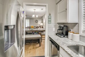 A modern kitchen with stainless steel appliances, a marble countertop, and a central island with seating. - Golf & Lake Gateway: Hot Springs Village Retreat (Hot Springs Village)