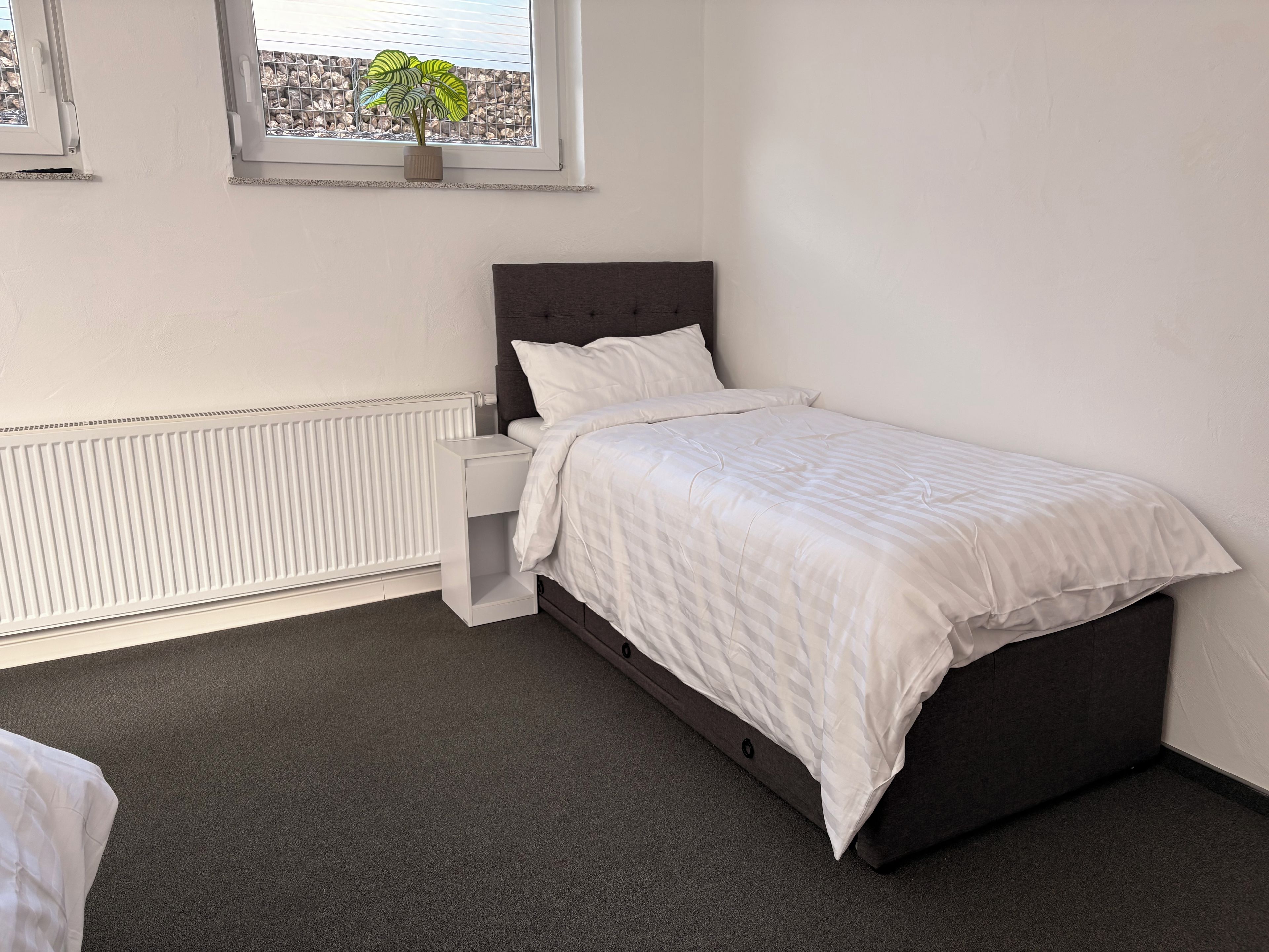 Une chambre à coucher avec un lit, une table de chevet et un radiateur.