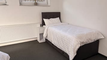 Une chambre à coucher avec un lit, une table de chevet et un radiateur.