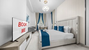 A modern hotel room with a large bed, a desk, a chair, a TV, and a 'BOOK ME' sign. - StayShort - Spectacular Studio in Arjan that Sleeps 2 (Arjan)