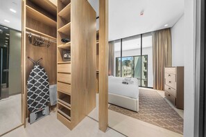 Ein modernes Hotelzimmer mit einem großen Bett, einem Kleiderschrank und Blick auf die Stadt.