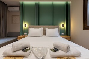 Ein Hotelzimmer mit einem Bett, zwei Nachttischen, einem Fenster und einer Klimaanlage.
