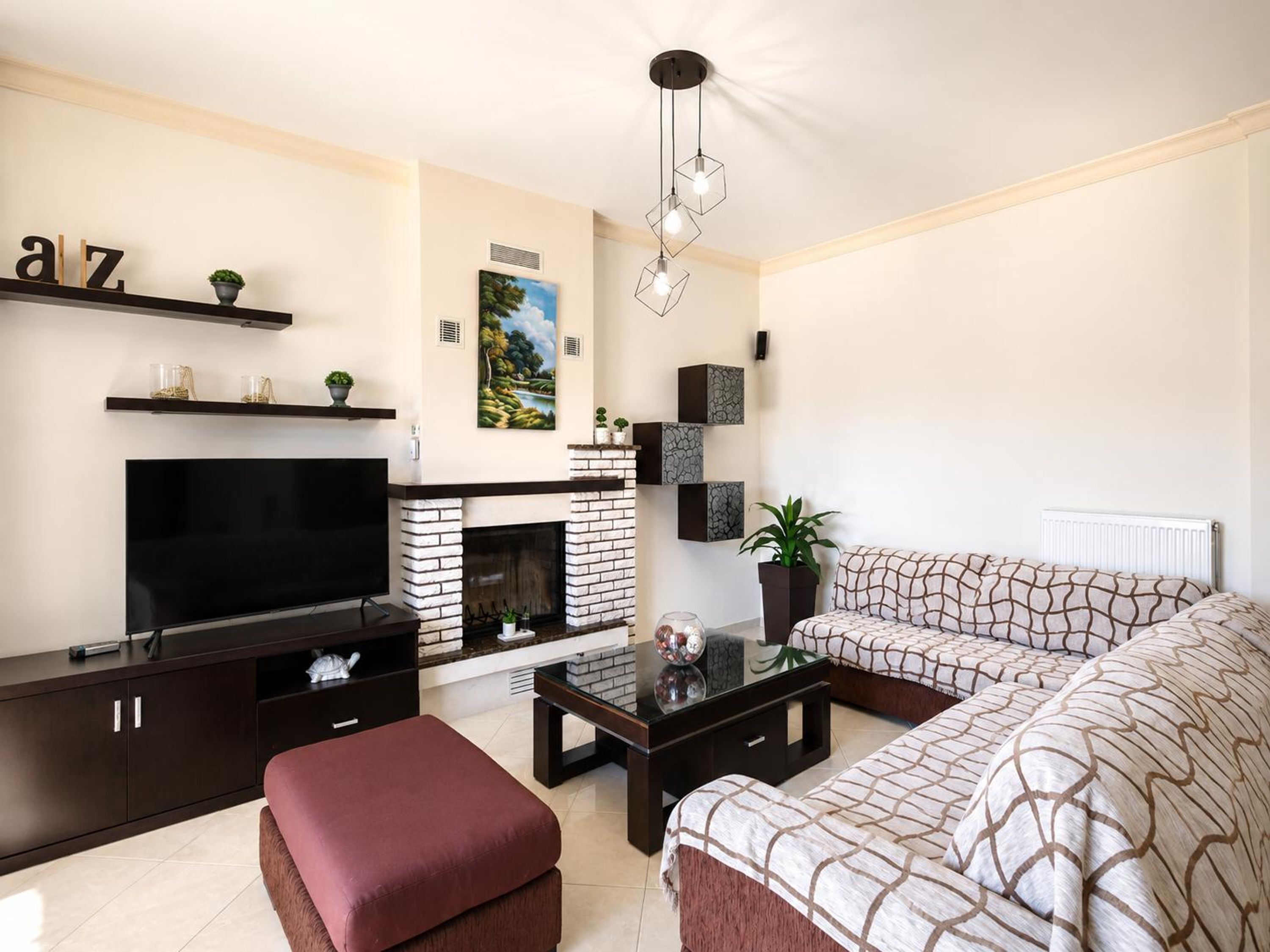 A modern living room with a fireplace, a flat-screen TV, a sofa, and a coffee table.