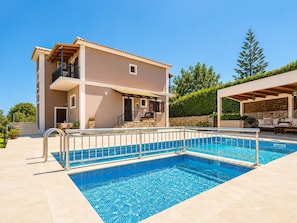 A two-story house with a swimming pool, outdoor seating, and a stone wall. - Villa Maggie Alonia in Zakinthos (Zakynthos)