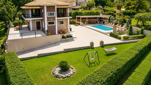 Ein mehrstöckiges Haus mit Swimmingpool, Sitzgelegenheiten im Freien und einem gepflegten Garten.