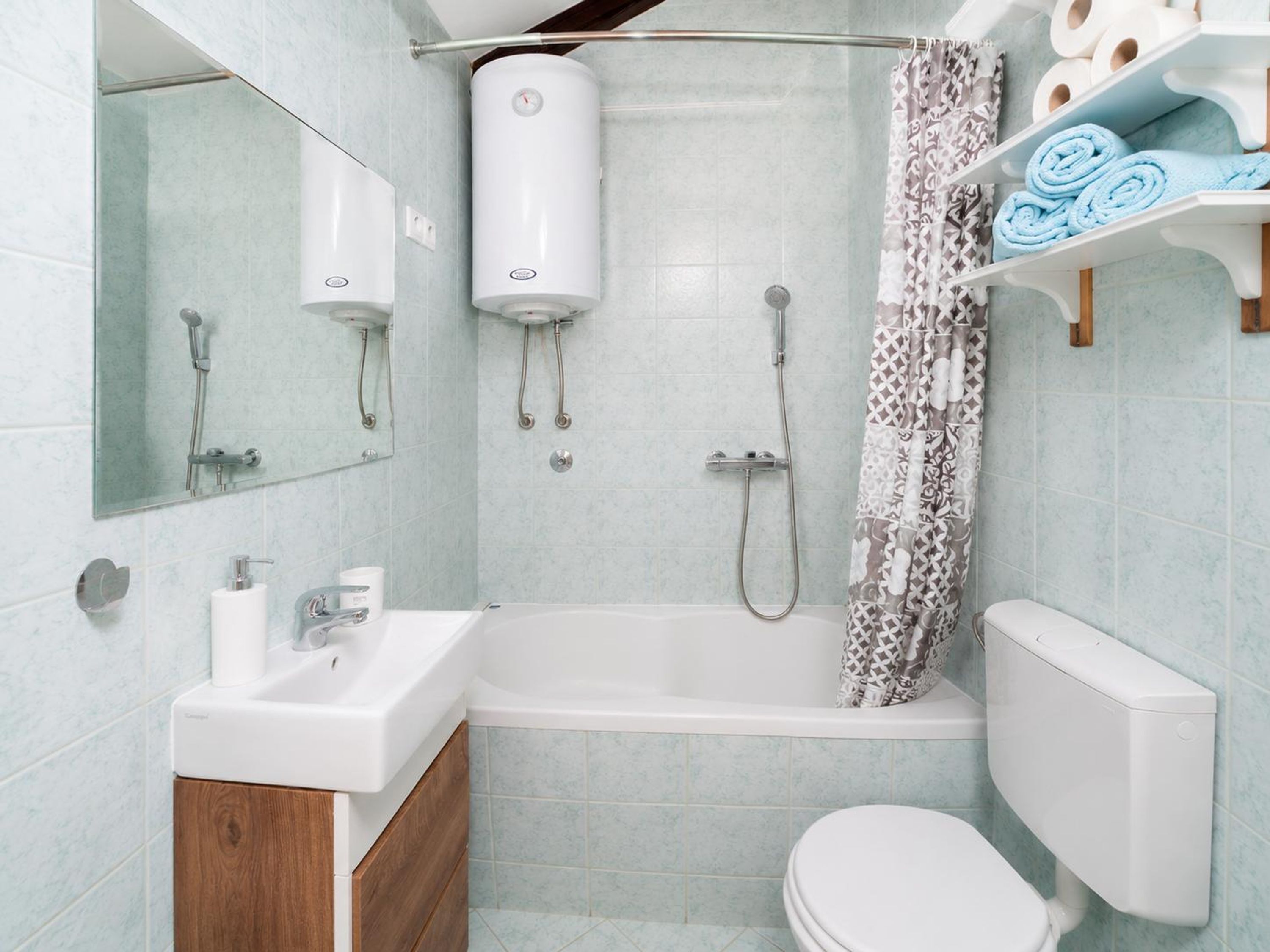 A bathroom with a bathtub, a toilet, a shower, a sink, and a mirror.