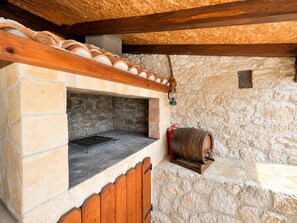 A stone oven with a wooden bench, a barrel, and a stone wall. - Didini Dvori in Kru evo (Obrovac)