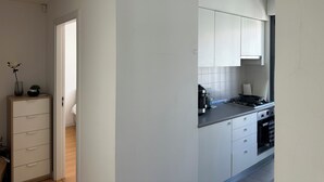 A modern kitchen with white cabinets, a countertop, and a stove. - Downtown Baixa-Rossio Central, Lisbon, with Parking (Lisboa)
