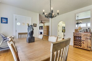 Ein Essbereich mit einem Holztisch, Stühlen, einer Kandelaber und einer Vitrine mit Weingläsern.