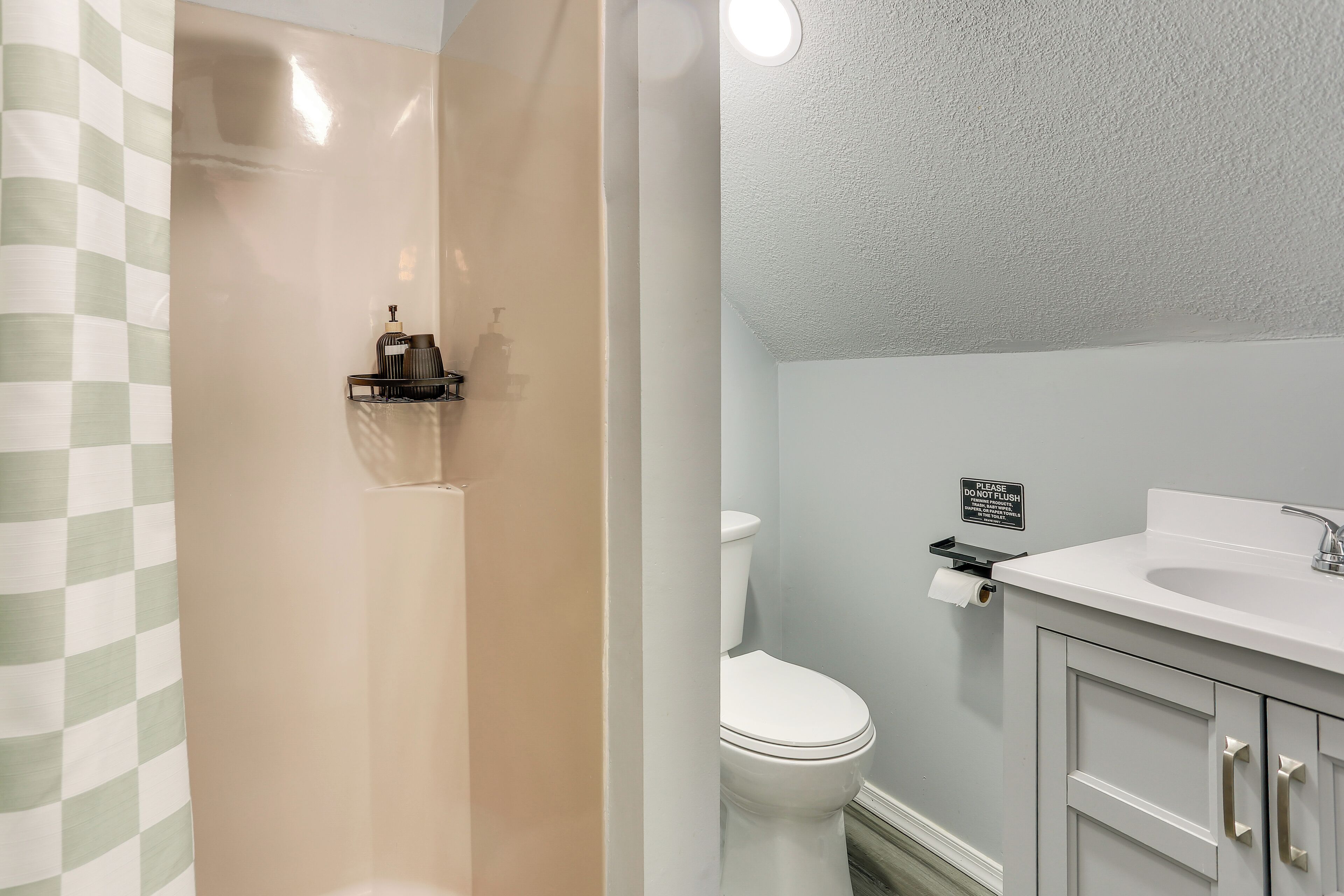 Un bagno con il water, lavabo e doccia.