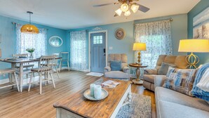 A living room with a ceiling fan, a dining table with chairs, a sofa, and a coffee table. - Downtown Gem: Walk to Restaurants & Palafox St! (Pensacola)