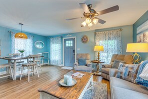 A living room with a ceiling fan, a dining table with chairs, a sofa, and a coffee table. - Downtown Gem: Walk to Restaurants & Palafox St! (Pensacola)