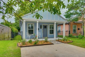 A single-story house with a porch, a fenced yard, and a small garden area. - Downtown Gem: Walk to Restaurants & Palafox St! (Pensacola)