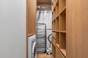 A laundry room with a washing machine, a drying rack, and a vacuum cleaner. - Riverside Residence • 1BR • Elevator • Old Town (Kraków)