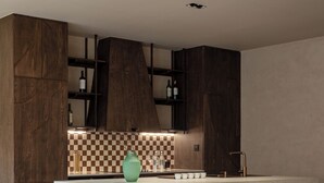 Una cocina moderna con barra, suelo de piedra y armarios de madera.