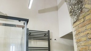 Ein Zimmer mit Ziegelwand, Metallgeländer und einer Deckenleuchte.