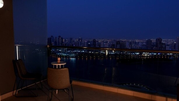 Un balcon donnant sur une vue panoramique de la ville la nuit.