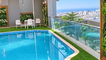 Shared building pool and seating area with city views