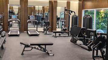 A gym with treadmills, weight machines, and exercise balls.