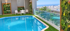 Shared building pool and seating area with city views