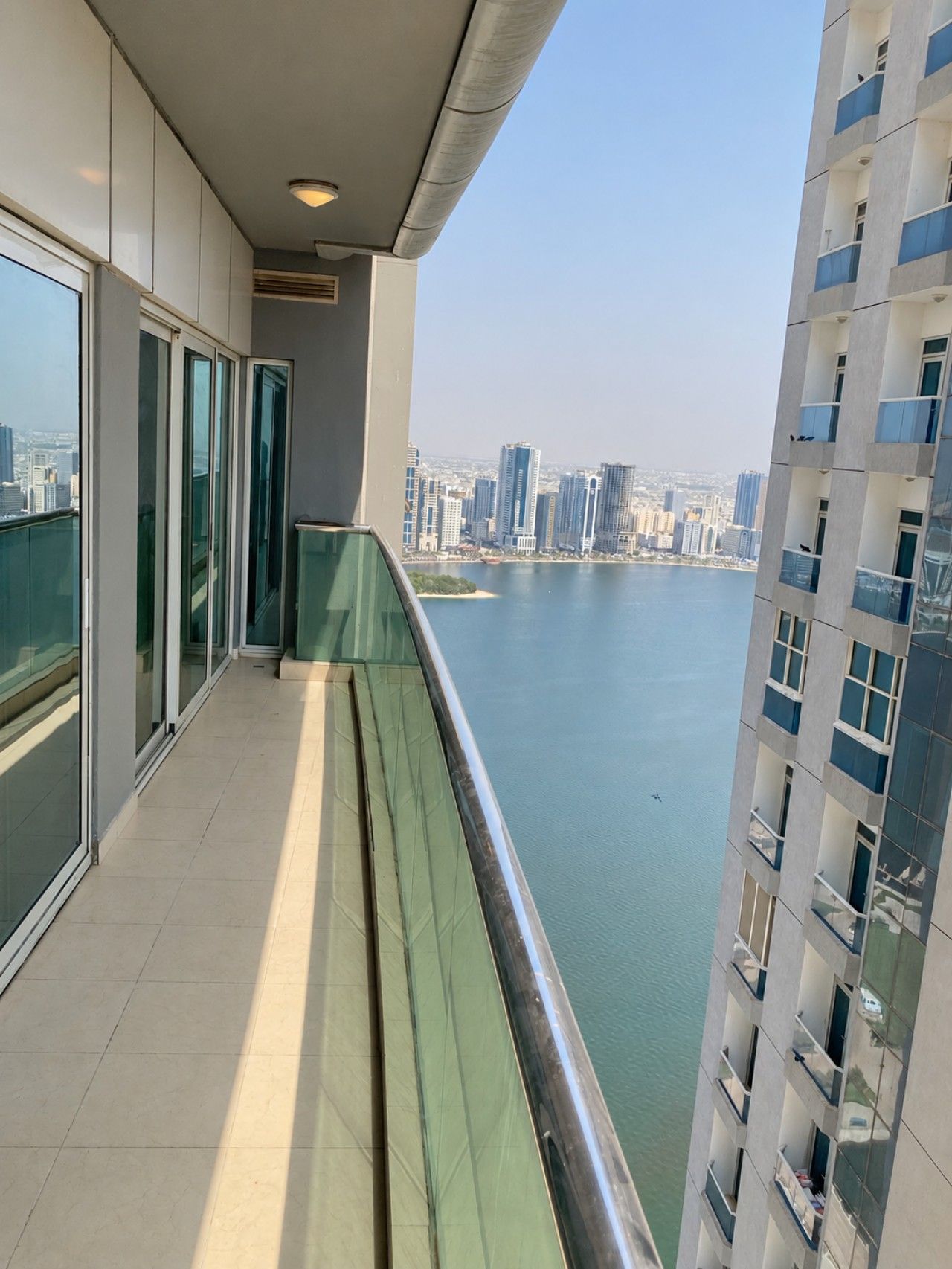 A balcony with a view of a city skyline and a body of water.