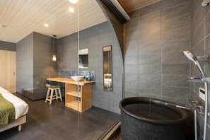 Une salle de bain moderne avec une grande baignoire, un meuble-lavabo en bois et un miroir.